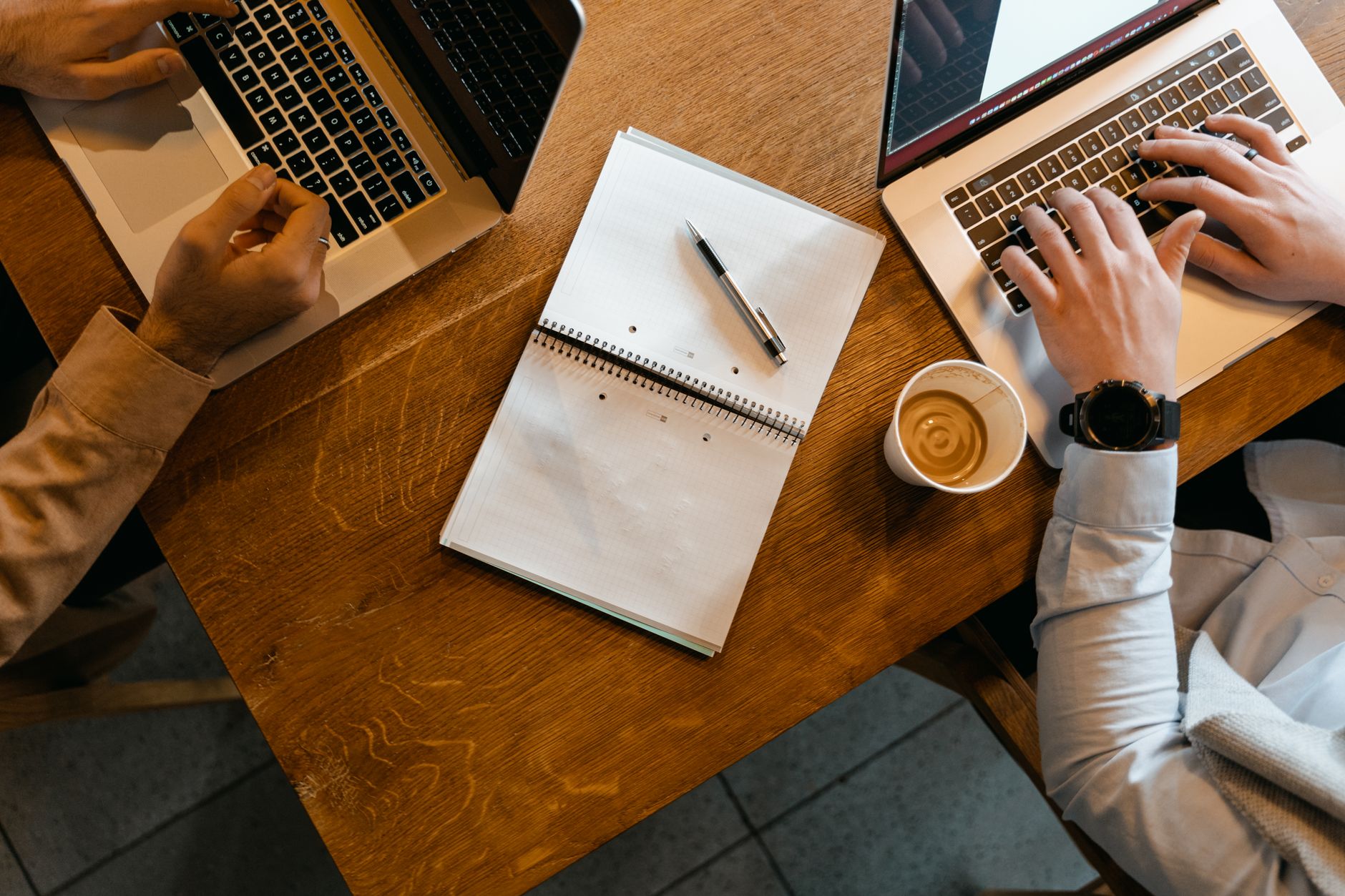 high angle shot of two people using their laptop while working in the office
